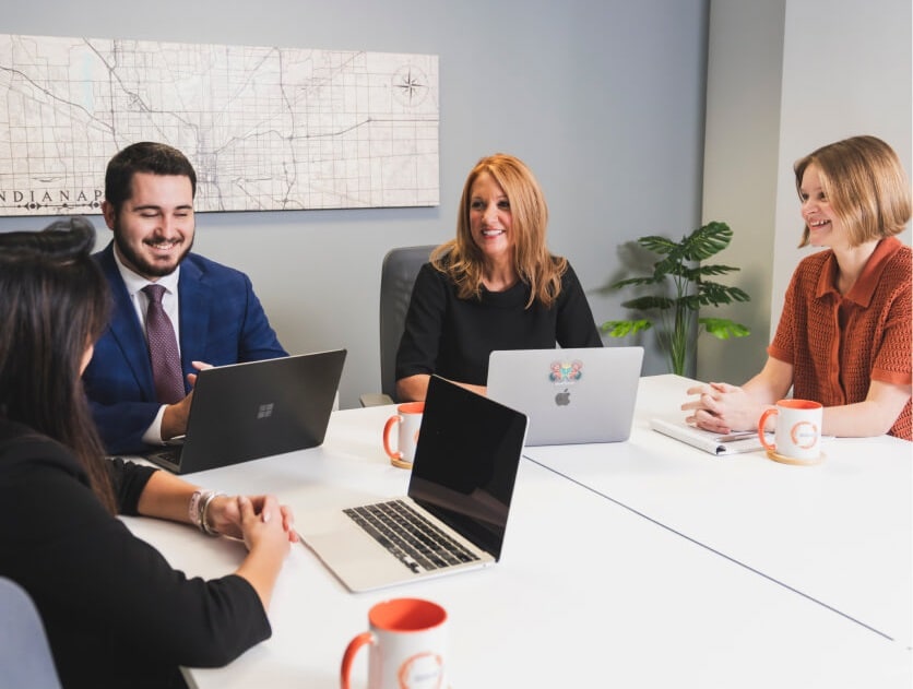 Hallowell Consulting team in conference room with laptops